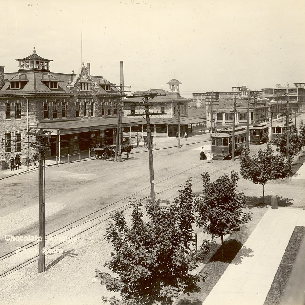 Buildings along a road with trolleys running through it. 