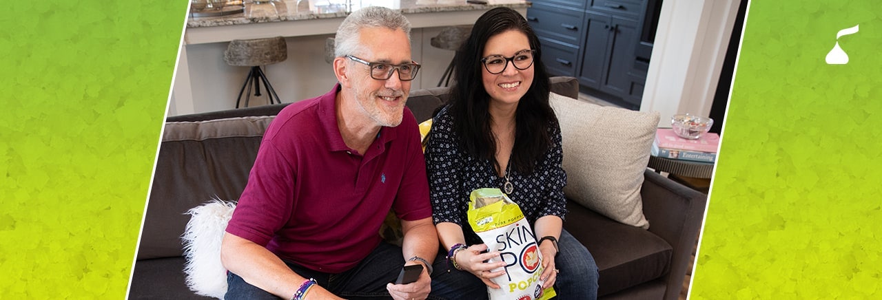 Two people enjoying snacks on couch