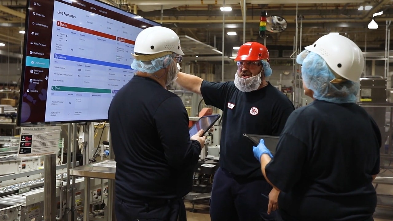 People reviewing metrics on a screen and tablets