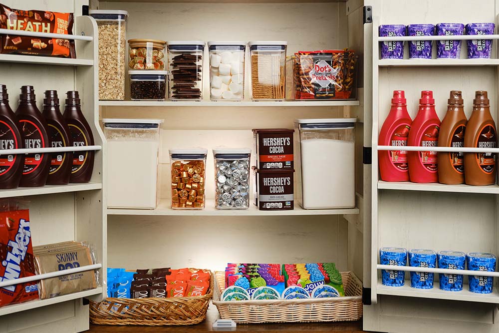 A variety of snacks stacked in an open cabinet