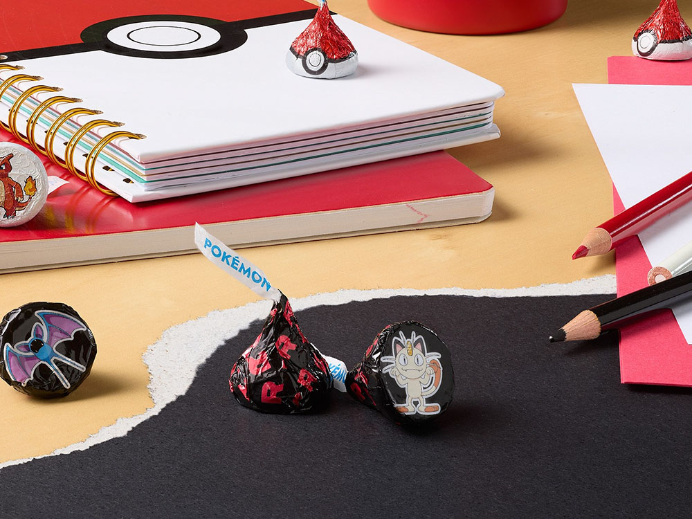 Pokemon branded Hershey's Kisses sitting on a desk next to pencils