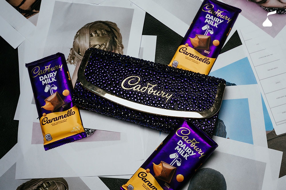 A limited-edition crystal-covered Cadbury clutch surrounded by Cadbury Dairy Milk Caramello bars