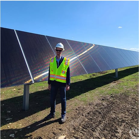 Man standing next to solar panels