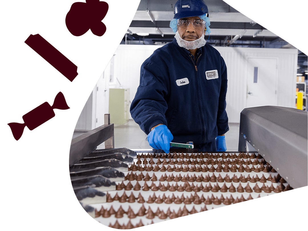 Person working in a Hershey plant looking at Hershey's Kisses